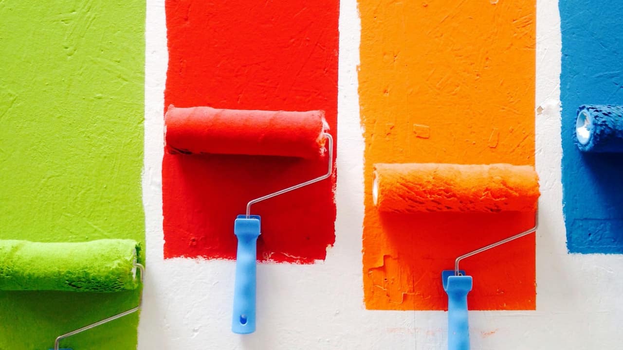 Painter applying paint to an exterior wall